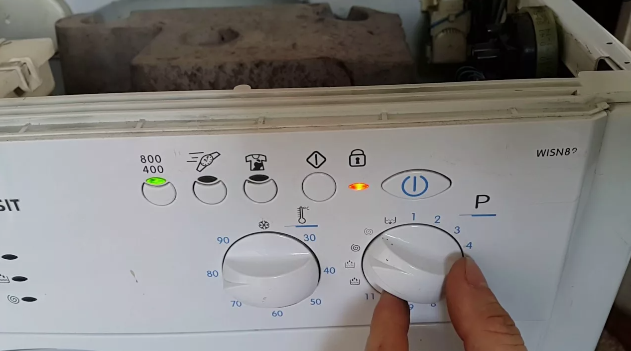 мастер по рбт осматривает стиральную машину indesit